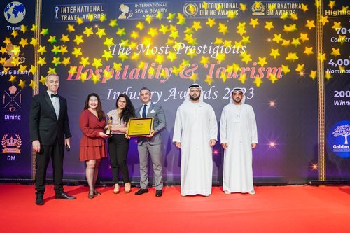 Hospitality award winners on stage, representing properties that track hospitality operating benchmarks